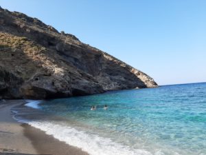 Greek coastline with a rock and swimmers
