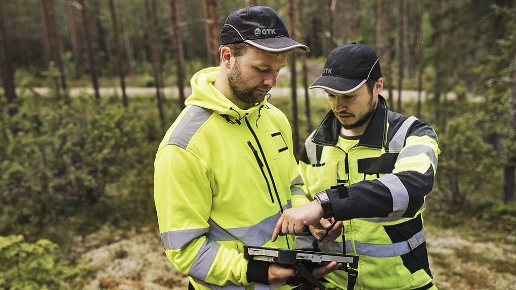 Kaksi henkilöä merkkaa maastohavaintoja maastotietokoneelle.