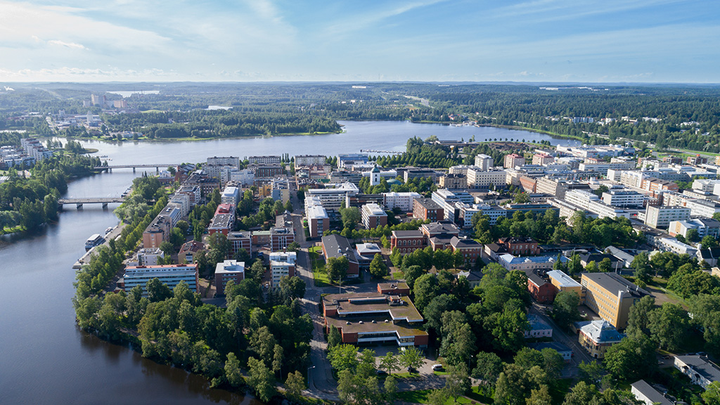 Kaunis ilmakuva Hämeenlinnasta aurinkoisena kesäpäivänä. Sininen taivas, kaupungin keskustaa ja viheralueita.