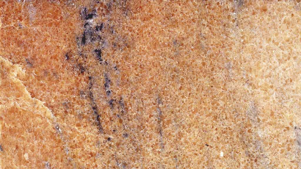Ruskeasävyinen kivipinta, jossa on harmaita juovia.