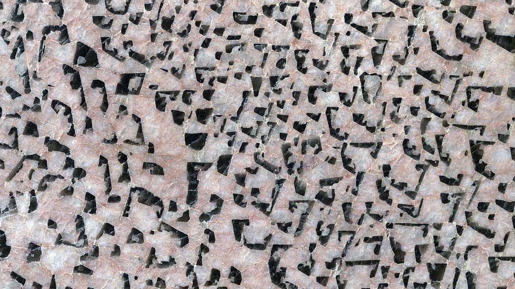 Kuvassa on kivi, jossa on vaaleanpunainen pohja ja epäsäännöllisiä mustia kuvioita.