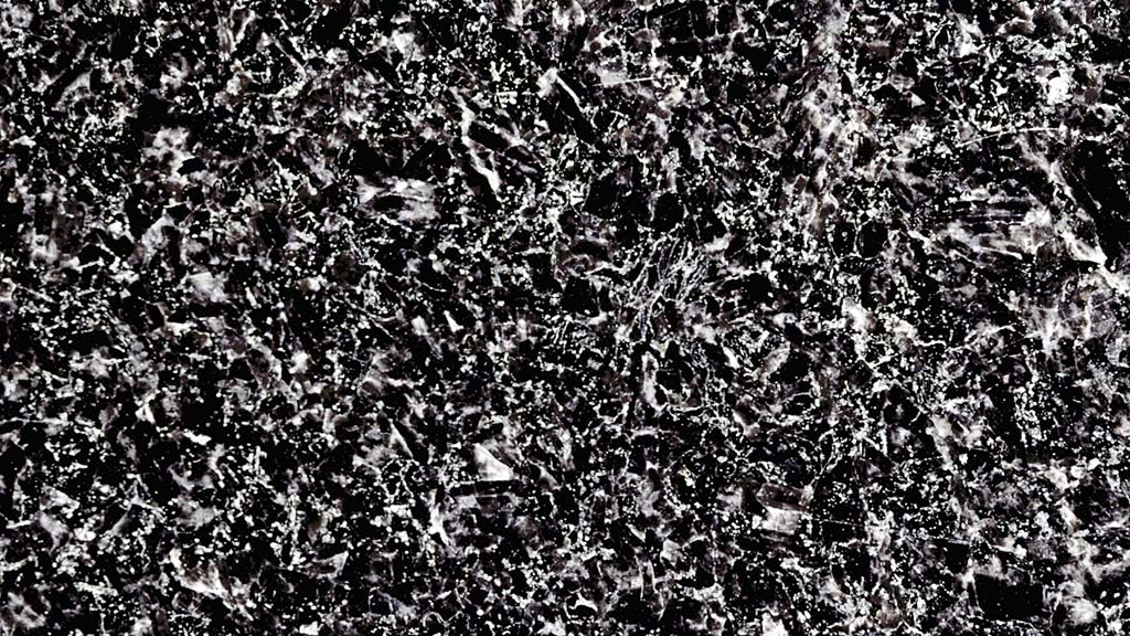 Kuvassa on musta kivi, jossa on tiheä valkoinen ja harmaa kuviointi.