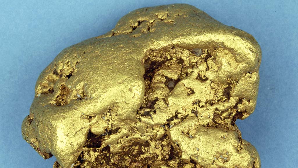 Kuvassa on kultahippu sinisellä taustalla.