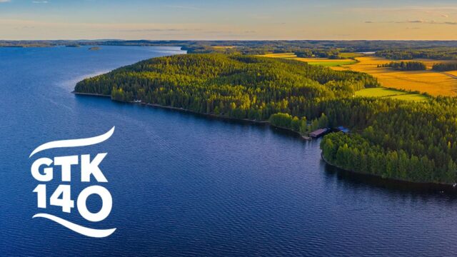 Järvi, metsää, peltoja ja tie ylhäältä kuvattuna.