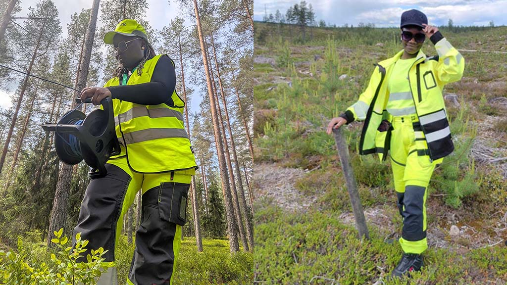 Two women standing in forest environment. Both have yellow working cloths on.