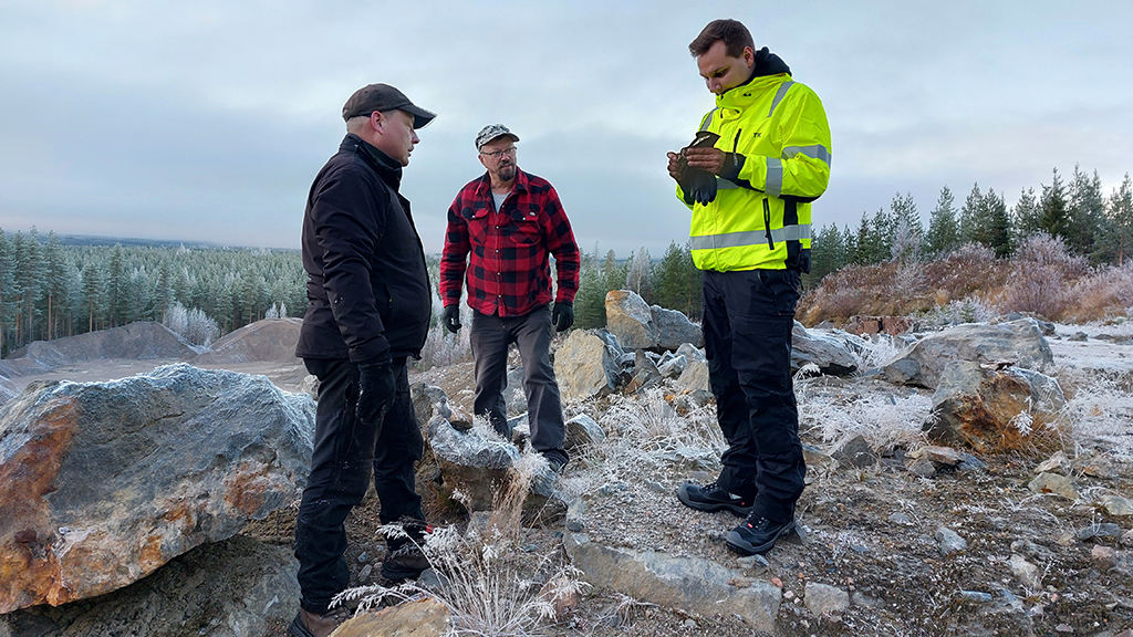 Kuvassa geologi Toni Liimatainen tutkii Jouni Nuutisen (vas.) ja Esko Rokkosen (kesk.) palkittua kansannäytettä Ilomantsista.