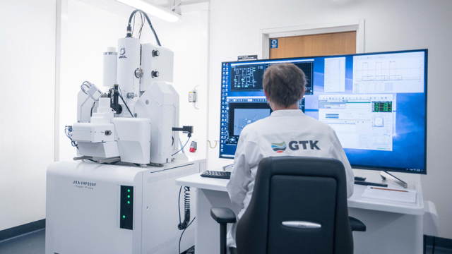 Forskaren arbetar framför en fältemissionsmikroanalysator och en monitor i forskningslaboratoriet.